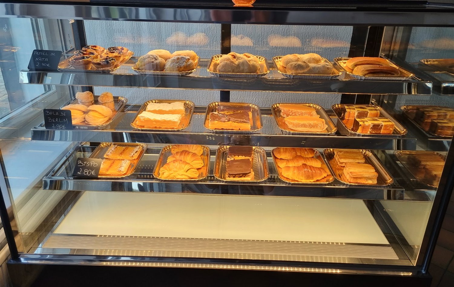 Glass pastry case with pastel de nata and Portuguese pastries