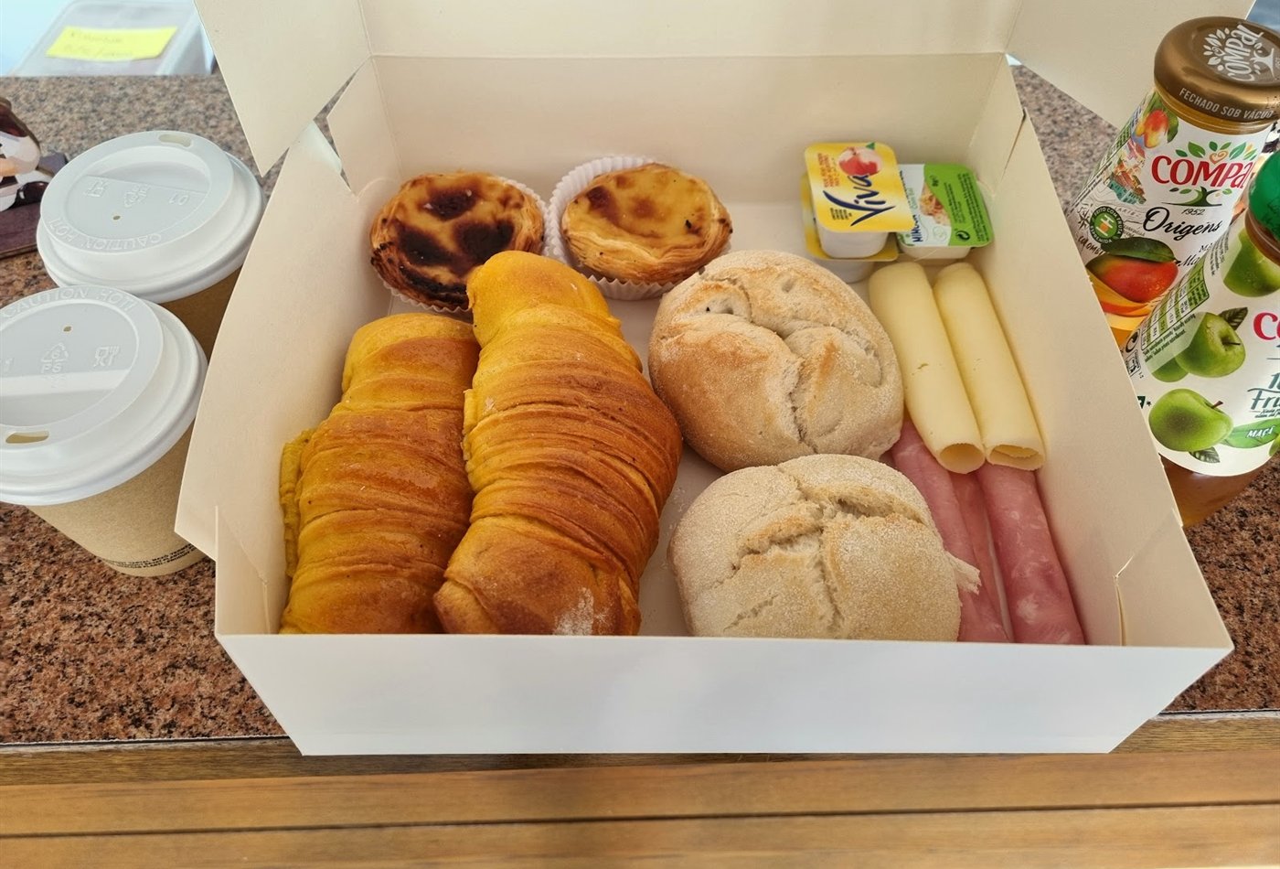 Takeaway breakfast box with pastel de nata, croissants and coffee